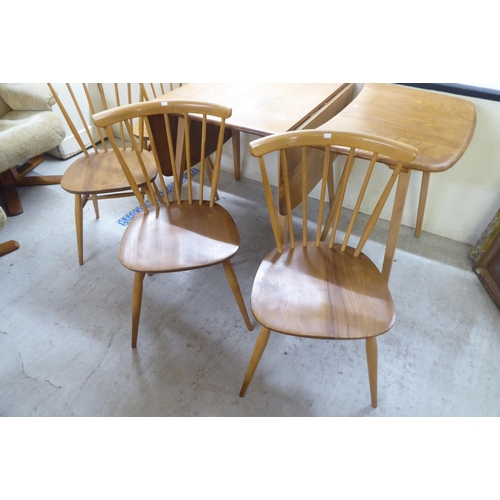 70 - An Ercol stained beech drop-leaf table, raised on tapered legs  27