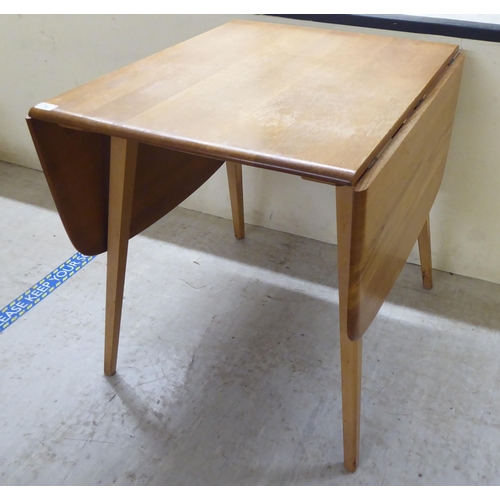 70 - An Ercol stained beech drop-leaf table, raised on tapered legs  27