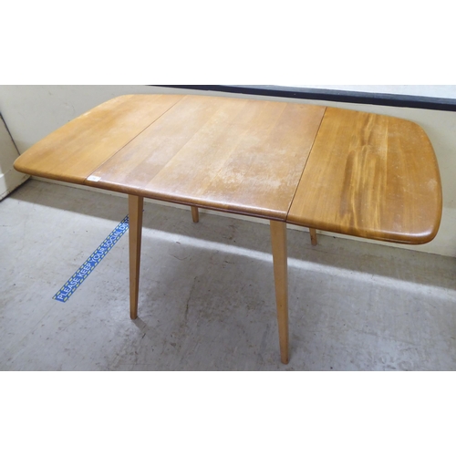 70 - An Ercol stained beech drop-leaf table, raised on tapered legs  27