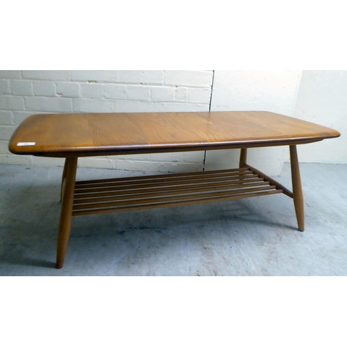 71 - An Ercol lozenge shaped beech and elm coffee table, raised on elliptically turned legs, united by a ... 