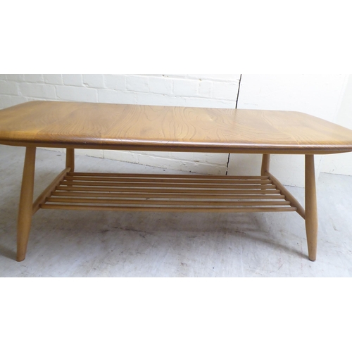 71 - An Ercol lozenge shaped beech and elm coffee table, raised on elliptically turned legs, united by a ... 