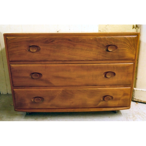 73 - An Ercol elm three drawer dressing chest, on a plinth and casters  26