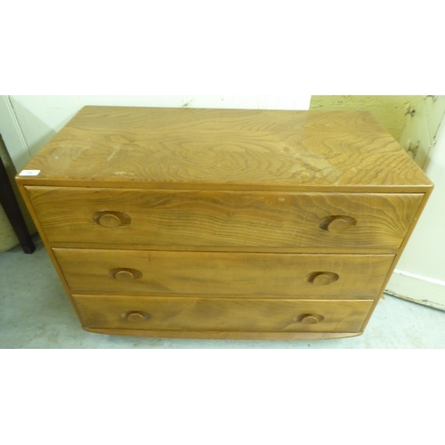 73 - An Ercol elm three drawer dressing chest, on a plinth and casters  26