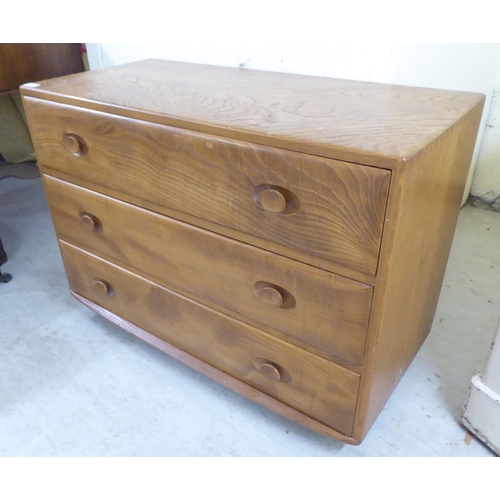 73 - An Ercol elm three drawer dressing chest, on a plinth and casters  26