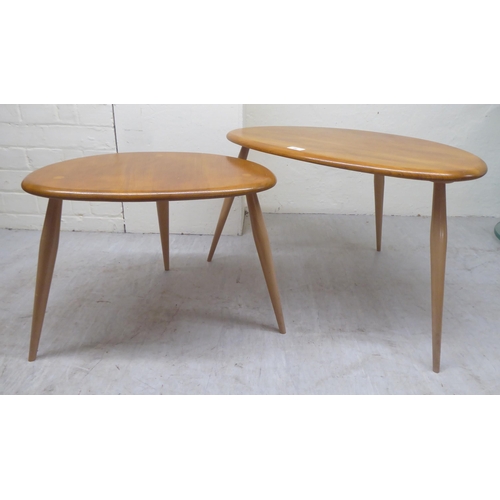 86 - A nesting set of two Ercol elm tables, raised on turned legs  largest 16