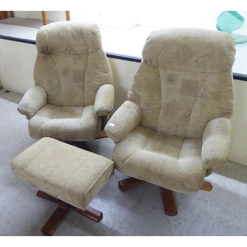 92 - A pair of modern patterned fabric upholstered, rotating armchairs, on splayed plinths