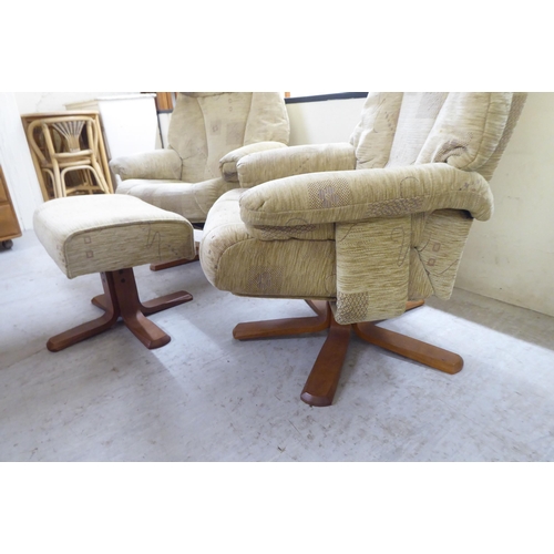 92 - A pair of modern patterned fabric upholstered, rotating armchairs, on splayed plinths