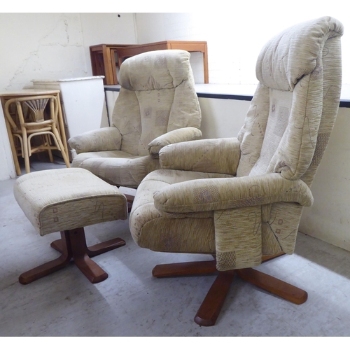 92 - A pair of modern patterned fabric upholstered, rotating armchairs, on splayed plinths