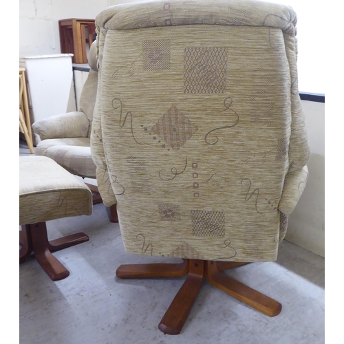 92 - A pair of modern patterned fabric upholstered, rotating armchairs, on splayed plinths