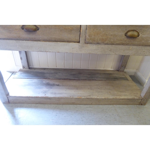 46 - A 20thC rustic and overpainted pine farmhouse style, two drawer dresser, raised on block legs, unite... 