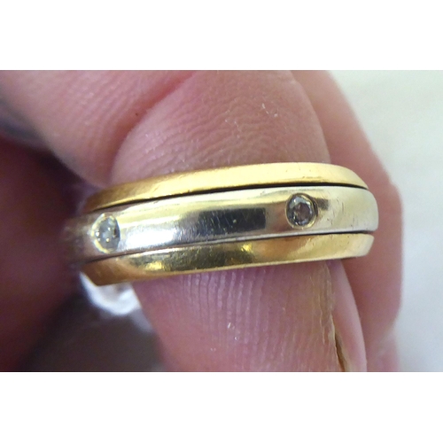 441 - A bi-coloured diamond set ring with a central spinning feature  stamped K18