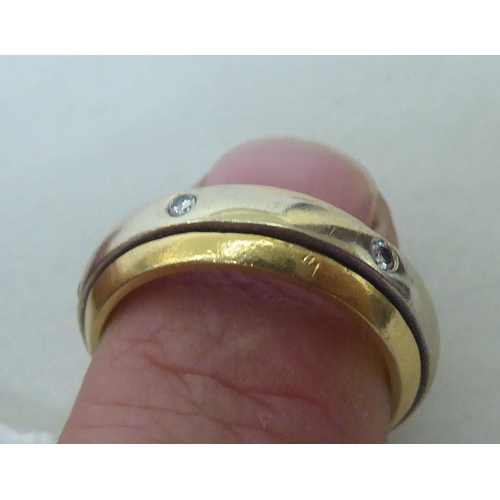 441 - A bi-coloured diamond set ring with a central spinning feature  stamped K18