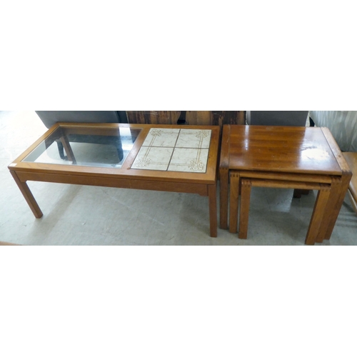 82 - A modern teak framed coffee table with a glass inset and four pottery tile top, raised on square leg... 