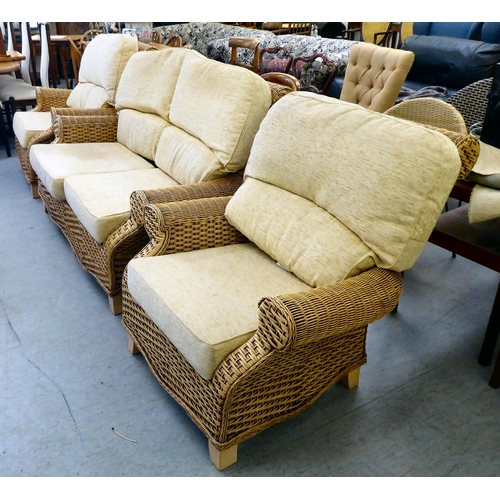 83 - A three piece caned conservatory suite, comprising a settee and two armchairs