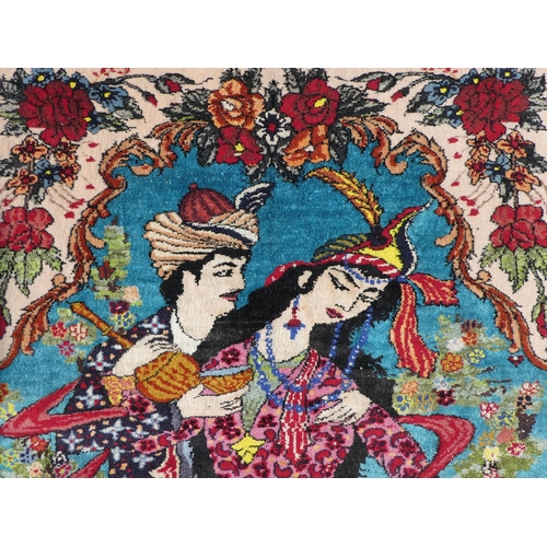 280 - An Afghan silk pictorial rug, decorated with a romantic couple, bordered by floral designs, on a mul... 