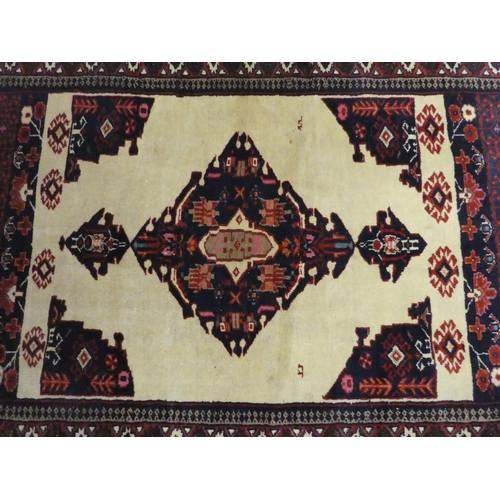 274 - A Persian rug, decorated with a central medallion, on a beige and maroon ground  64