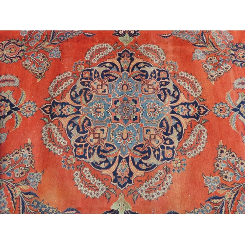 285 - An antique Kashan carpet, decorated with mainly floral designs, on a red ground  144