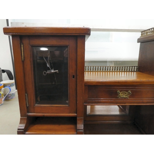 106 - An Edwardian mahogany one-piece writing desk, the desk top with glazed and drawer sections, incorpor... 