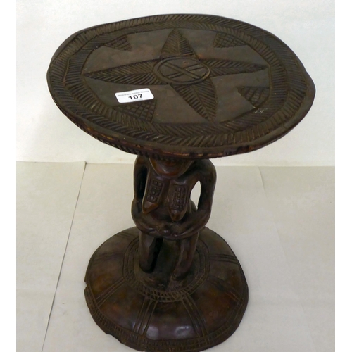 107 - An African carved wooden stool, fashioned as a native woman, on a circular base  16