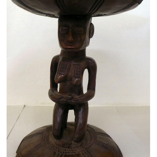 107 - An African carved wooden stool, fashioned as a native woman, on a circular base  16