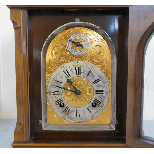 21 - A late 19thC walnut cased bracket clock, having an arched pediment, finials and fretworked flanks, o... 