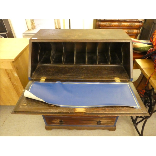 257 - A mid 20thC oak bureau with a fall flap, over three long drawers, raised on bracket feet  39