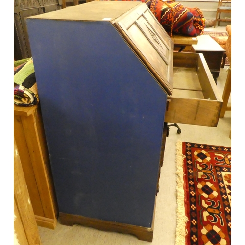 257 - A mid 20thC oak bureau with a fall flap, over three long drawers, raised on bracket feet  39