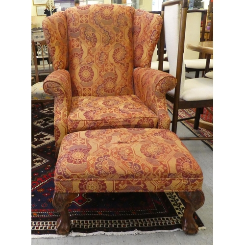 261 - A modern orange and red floral fabric upholstered wingback arm chair, raised on cabriole legs; and a... 