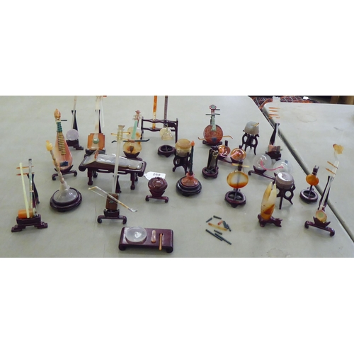 268 - Modern jade coloured and hardstone musical instruments with individual rosewood stands