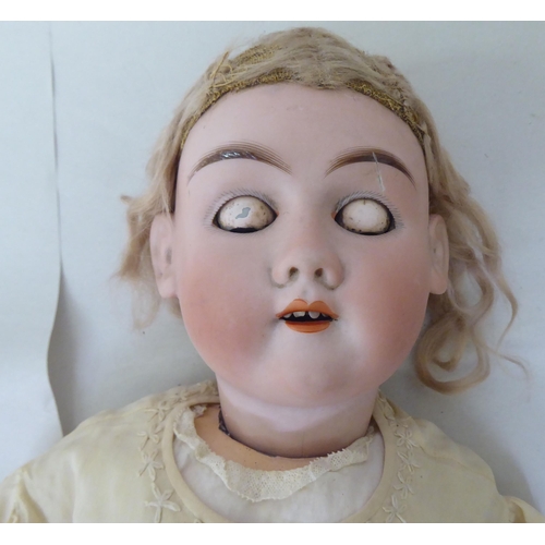 283 - An early 20thC Hanswerck bisque head doll with weighted sleeping eyes and painted features, on a joi... 