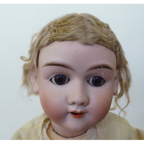 283 - An early 20thC Hanswerck bisque head doll with weighted sleeping eyes and painted features, on a joi... 