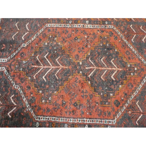 296 - A Persian rug with floral decoration, on a red ground  44