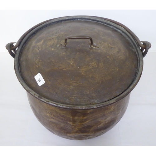 59 - An antique Continental brass finished cauldron with a lid and folding top handle  14