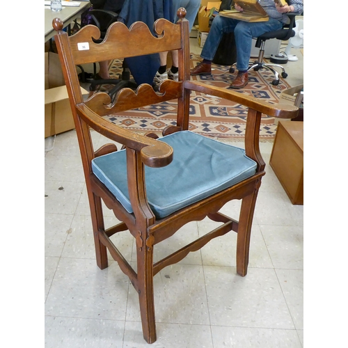 96 - A 19th/20thC country made, oak framed elbow chair with a low ladder back and open, level arms, the s... 