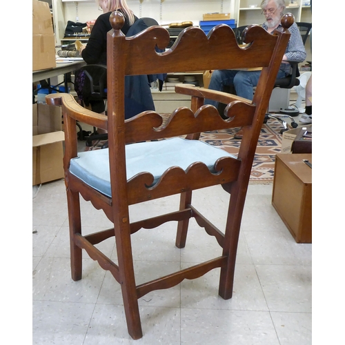 96 - A 19th/20thC country made, oak framed elbow chair with a low ladder back and open, level arms, the s... 