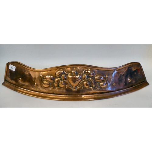 116 - An Arts & Crafts copper fire curb of curved form, embossed with soft fruit, around a central hea... 