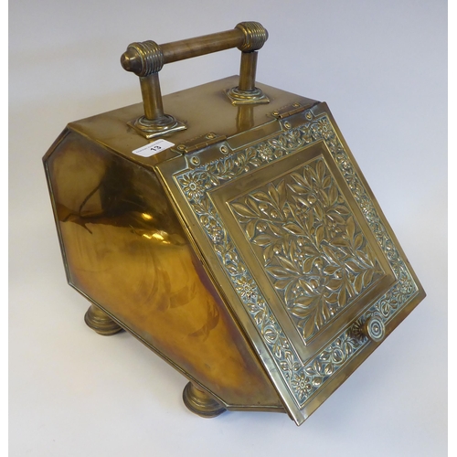 13 - A late Victorian brass coal box with an angled, hinged lid, embossed with flora and foliage