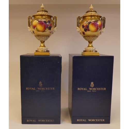 14 - A pair of Royal Worcester china, twin handled, spherical, pedestal vases and covers, decorated with ... 