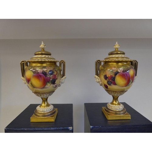 14 - A pair of Royal Worcester china, twin handled, spherical, pedestal vases and covers, decorated with ... 