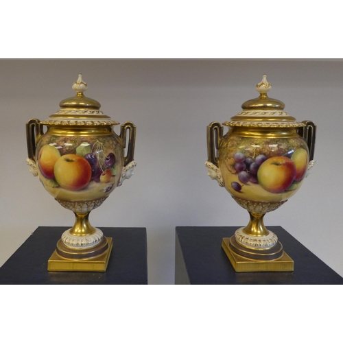 14 - A pair of Royal Worcester china, twin handled, spherical, pedestal vases and covers, decorated with ... 