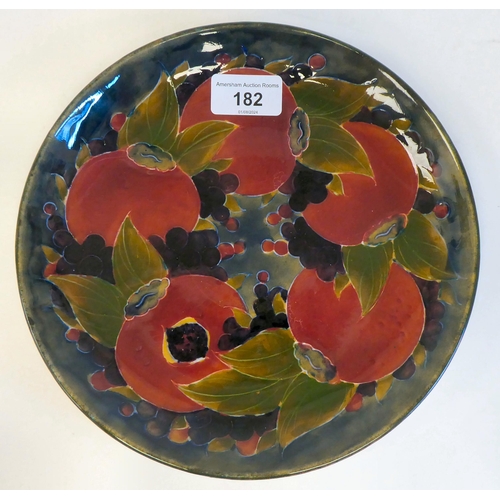 182 - A Moorcroft pottery dish, decorated in colours with a version of the Pomegranate design  bears ... 