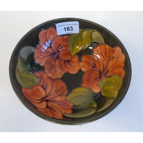 183 - A Moorcroft pottery footed bowl, decorated in tubeline and colours with a version of The Hibiscus de... 