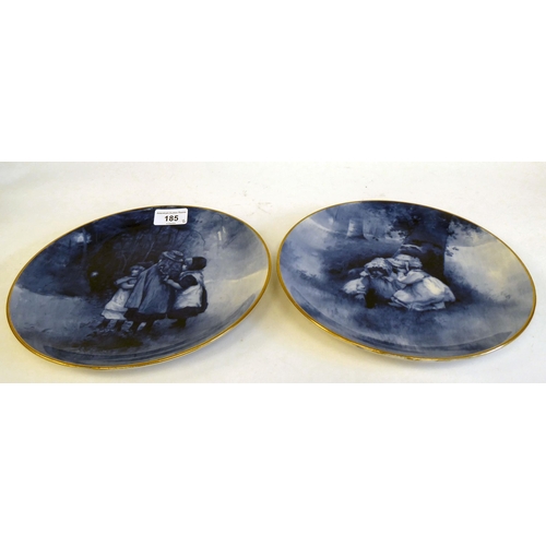 185 - A pair of Royal Doulton china wall plates, decorated in blue and white with children hiding in woodl... 