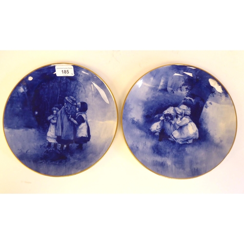 185 - A pair of Royal Doulton china wall plates, decorated in blue and white with children hiding in woodl... 