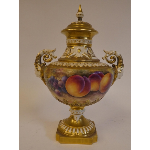 19 - A Royal Worcester china, twin handled pedestal vase and cover, decorated with soft fruit and gilding... 