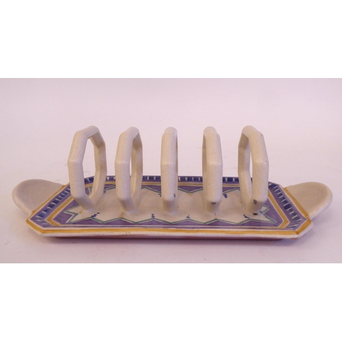 193 - A Poole pottery four division toastrack with octagonal divisions, on a painted tray base