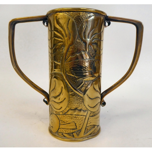 194 - An Arts and Crafts brass vase of cylindrical form with opposing strap handles, embossed with stylise... 