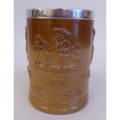 195 - A two tone brown glazed stoneware harvest mug with a loop handle and applied silver rim  maker'... 