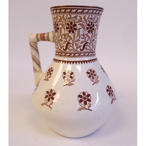 203 - A Mintons cream coloured and brown glazed ewer, traditionally decorated in floral designs  bear... 