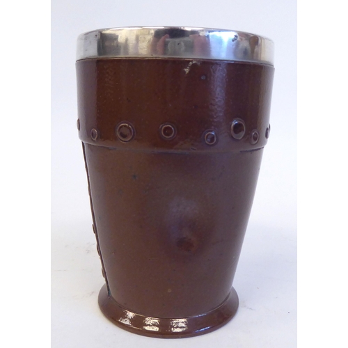 205 - A Doulton Lambeth Siliconware beaker, fashioned as if leather with an applied silver rim  HTB  Londo... 